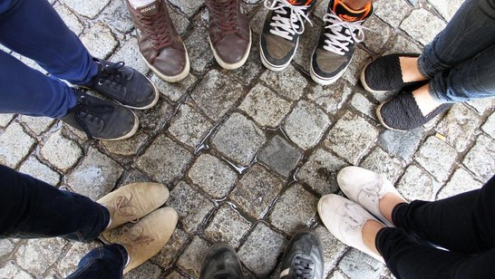 im Kreis stehende Füße in Schuhen